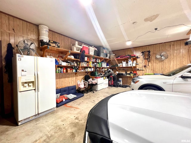 garage with wooden walls and white fridge with ice dispenser