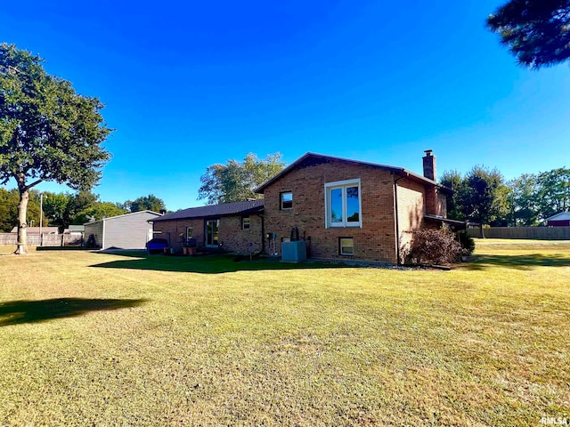 back of house featuring a lawn and cooling unit