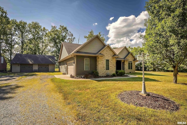 craftsman-style home featuring an outbuilding, an attached garage, driveway, and a front lawn