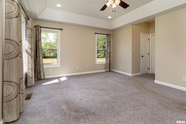 unfurnished room featuring recessed lighting, a raised ceiling, visible vents, carpet flooring, and baseboards