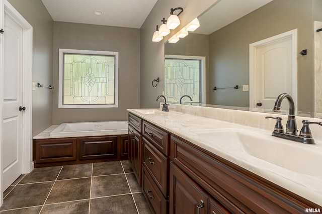 full bathroom featuring double vanity, a garden tub, tile patterned flooring, and a sink