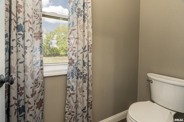 bathroom featuring toilet and baseboards