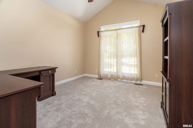 unfurnished office featuring lofted ceiling, light colored carpet, visible vents, ceiling fan, and baseboards