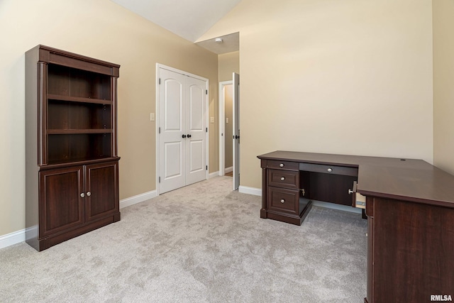 carpeted home office featuring vaulted ceiling and baseboards