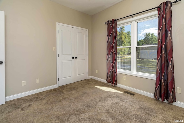 unfurnished bedroom with baseboards, visible vents, and carpet flooring