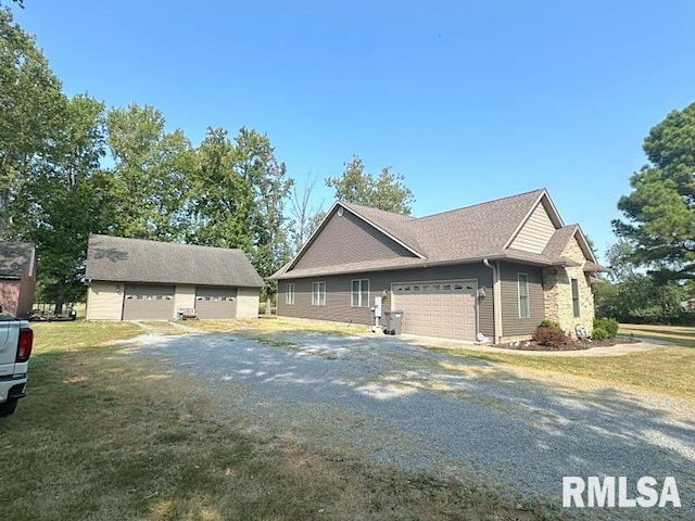 view of property exterior with a garage, a lawn, and an outbuilding