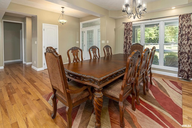 dining area featuring a chandelier, light wood-type flooring, and baseboards