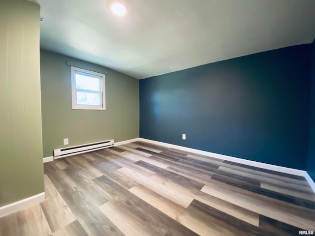 spare room with light wood-type flooring and baseboard heating