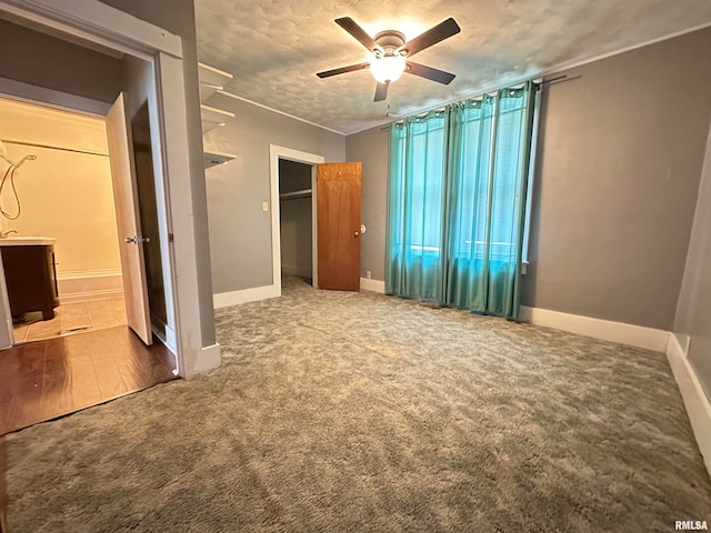 unfurnished bedroom featuring ceiling fan, a closet, a textured ceiling, and hardwood / wood-style flooring