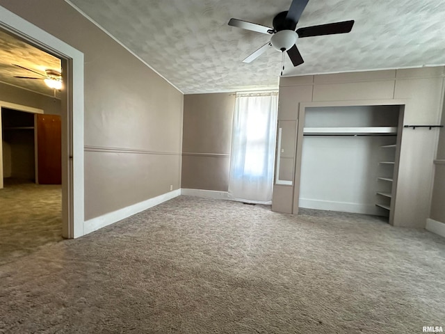 unfurnished bedroom with a textured ceiling, ceiling fan, carpet floors, a closet, and lofted ceiling