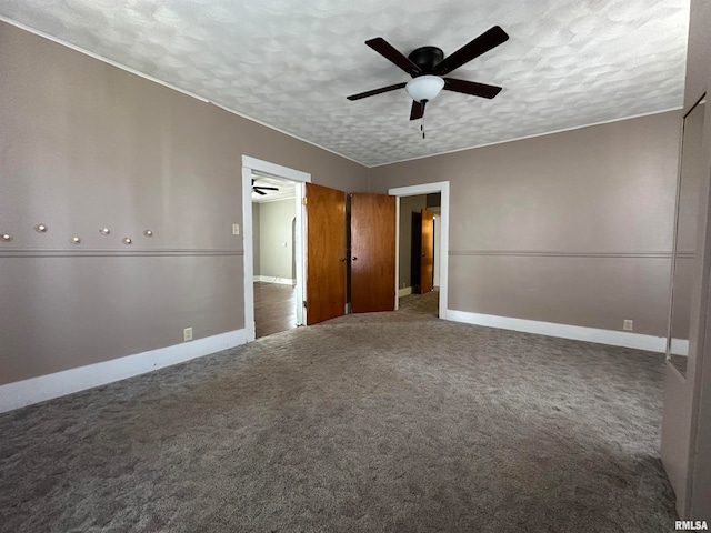 carpeted spare room featuring ceiling fan and a textured ceiling