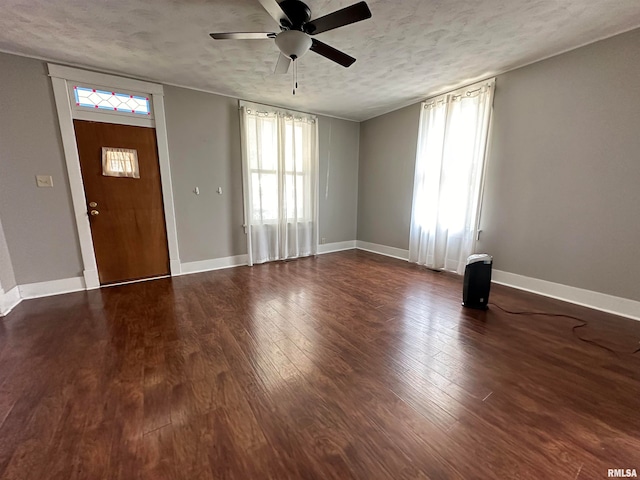 foyer with a textured ceiling, dark hardwood / wood-style floors, plenty of natural light, and ceiling fan