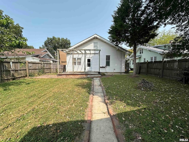 back of house with a lawn and a pergola