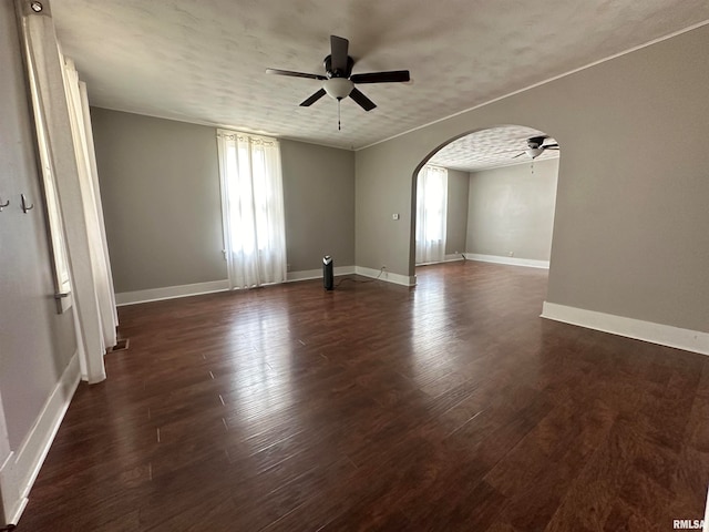 spare room with a textured ceiling, ceiling fan, and dark hardwood / wood-style floors