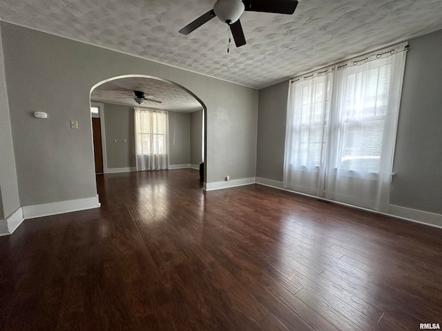 empty room with ceiling fan, dark hardwood / wood-style floors, and a textured ceiling