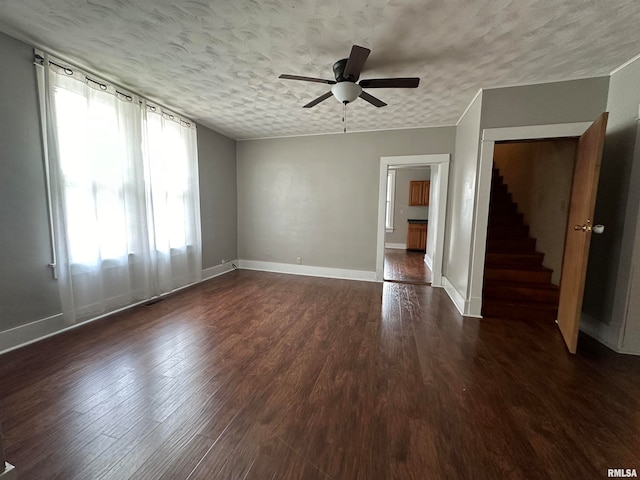 empty room featuring ceiling fan, dark hardwood / wood-style flooring, and a textured ceiling