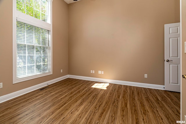 unfurnished room with hardwood / wood-style flooring and a healthy amount of sunlight