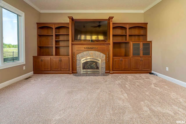 unfurnished living room with ornamental molding, a tiled fireplace, and carpet flooring