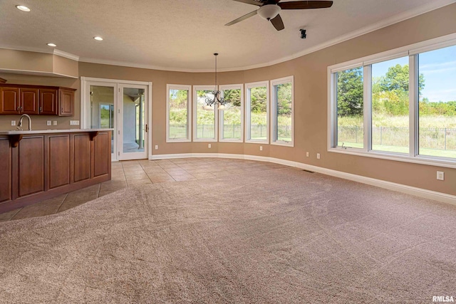 interior space with ceiling fan with notable chandelier, hanging light fixtures, light carpet, and crown molding