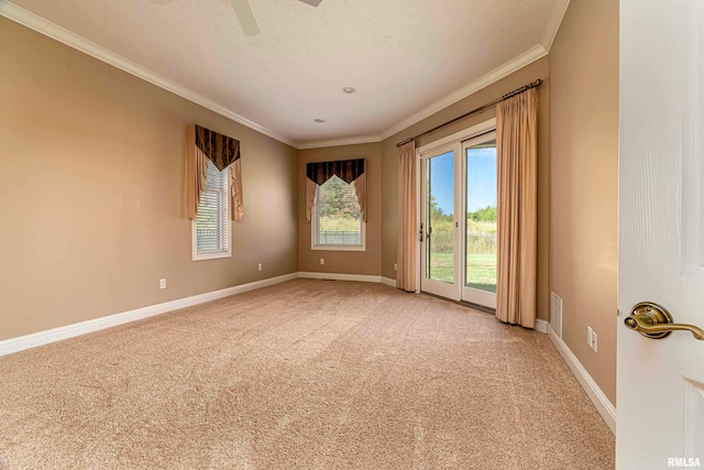 carpeted empty room featuring a textured ceiling, ornamental molding, and ceiling fan