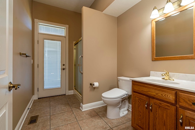 bathroom featuring walk in shower, vanity, tile patterned flooring, and toilet