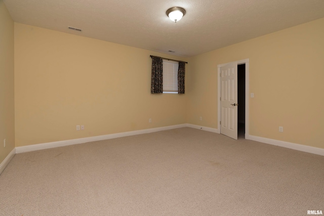 unfurnished room featuring a textured ceiling and carpet