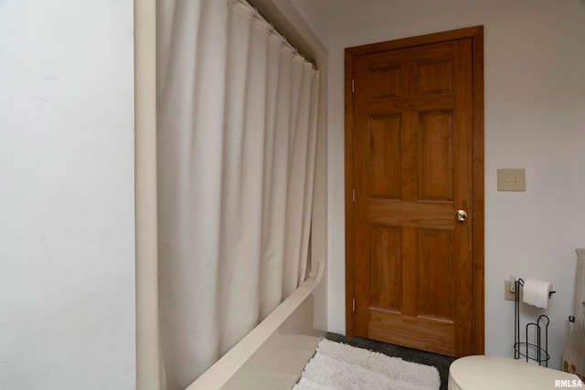 bathroom with shower / bath combo with shower curtain and toilet