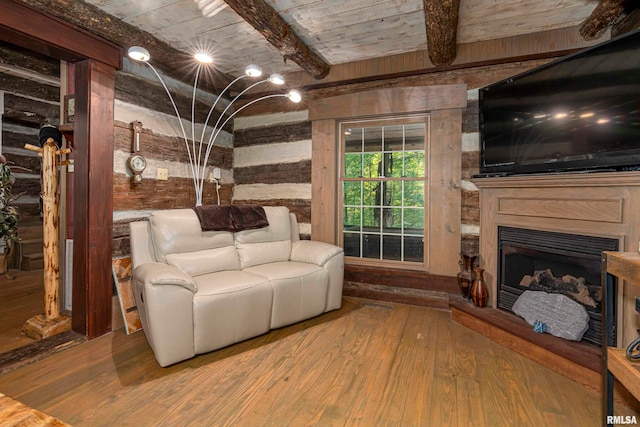 living room with wood walls, beam ceiling, and hardwood / wood-style flooring