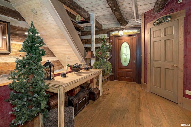 entryway with wooden ceiling, wooden walls, lofted ceiling with beams, and hardwood / wood-style flooring