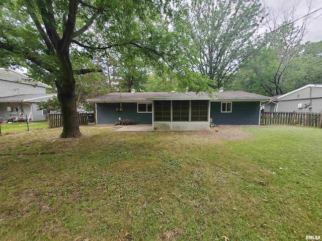 rear view of house with a yard, a patio area, and a sunroom