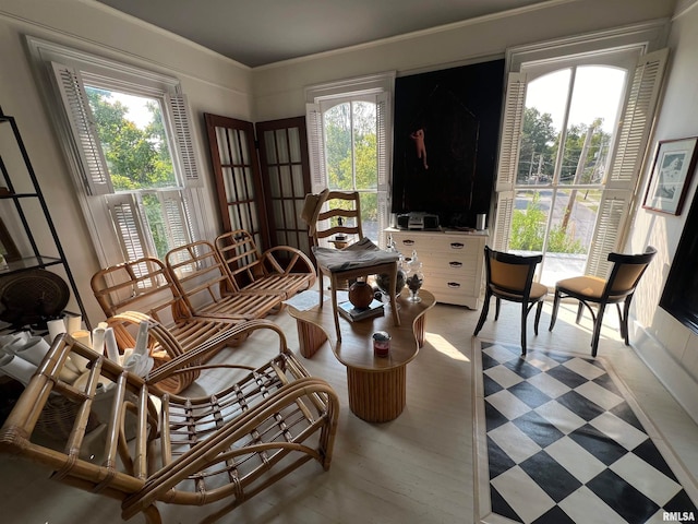 living room featuring a wealth of natural light, ornamental molding, and hardwood / wood-style floors