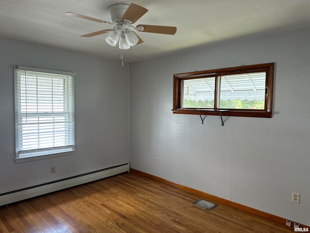 empty room with a baseboard heating unit, ceiling fan, and hardwood / wood-style flooring