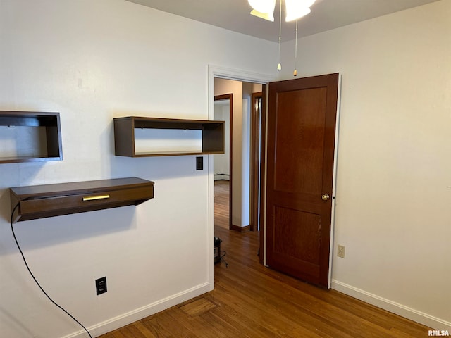 corridor featuring a baseboard radiator and wood-type flooring