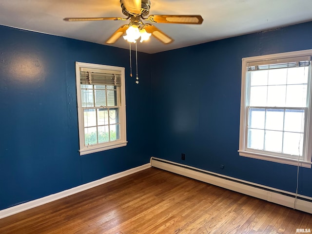 empty room with a baseboard heating unit, hardwood / wood-style floors, and ceiling fan