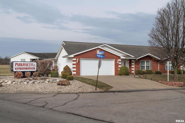 ranch-style house with a garage, concrete driveway, brick siding, and roof with shingles