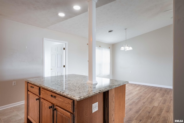 1500 Apache Dr, Marion, IL 62959 - kitchen featuring brown cabinetry, light stone counters, baseboards, recessed lighting, and decorative columns