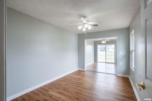 1500 Apache Dr, Marion, IL 62959 - spare room featuring wood finished floors, a ceiling fan, baseboards, and a textured ceiling