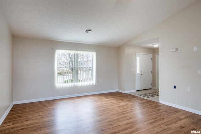 1500 Apache Dr, Marion, IL 62959 - kitchen featuring wood finished floors, brown cabinets, baseboards, hanging light fixtures, and vaulted ceiling