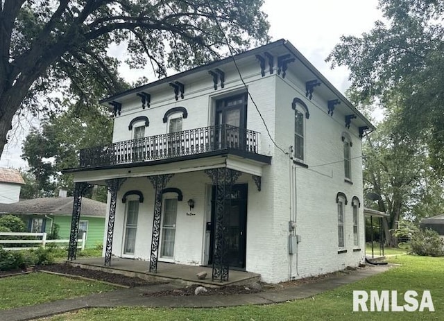 italianate house with a porch, a balcony, and a front yard