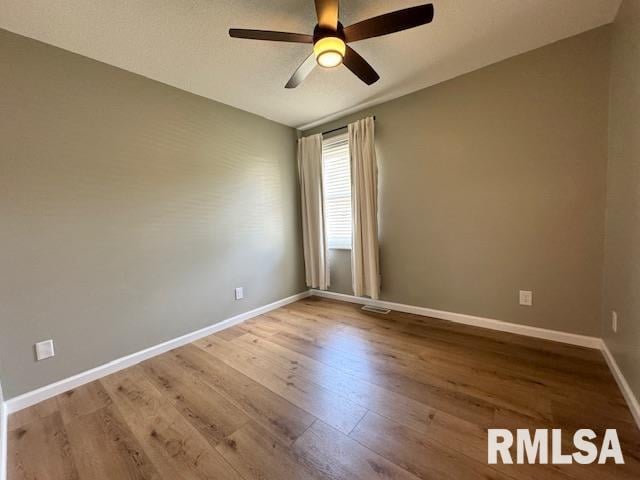 empty room featuring wood-type flooring and ceiling fan