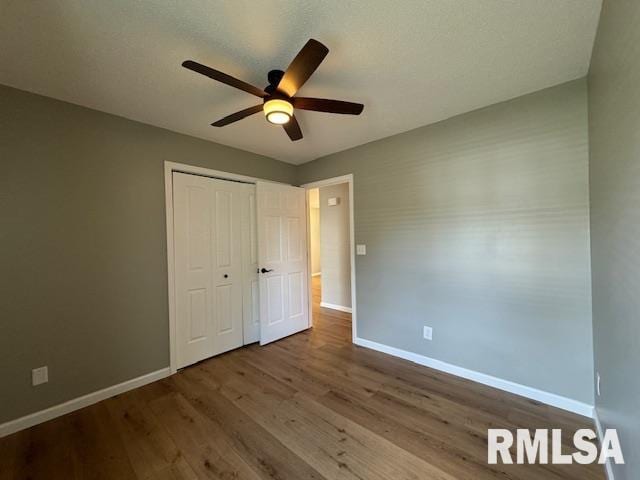 unfurnished bedroom with a closet, ceiling fan, and wood-type flooring