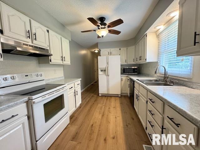 kitchen with ceiling fan, light wood-type flooring, white appliances, and white cabinets