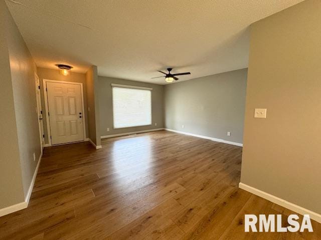 interior space with dark hardwood / wood-style flooring, ceiling fan, and a textured ceiling