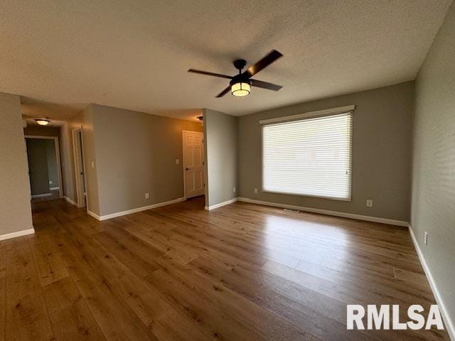 spare room with dark wood-type flooring, ceiling fan, and a textured ceiling