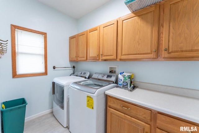 washroom featuring cabinets, light hardwood / wood-style flooring, and independent washer and dryer