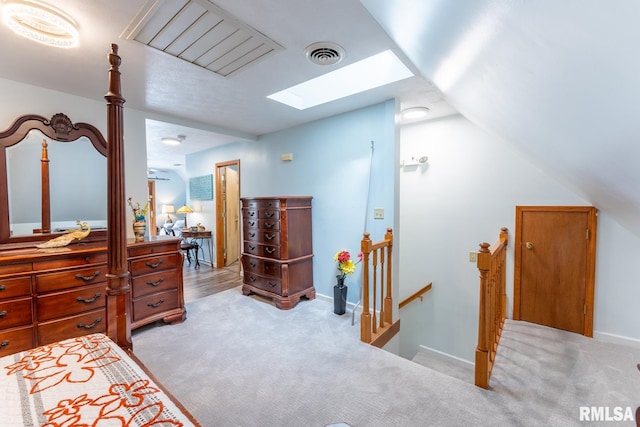 bedroom featuring light carpet and lofted ceiling with skylight