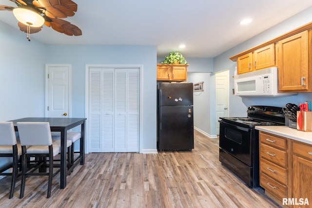 kitchen featuring ceiling fan, light wood-type flooring, and black appliances