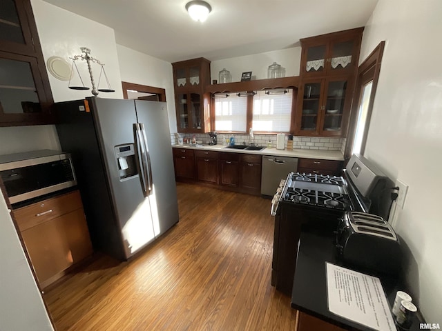 kitchen with sink, stainless steel appliances, backsplash, and dark hardwood / wood-style flooring