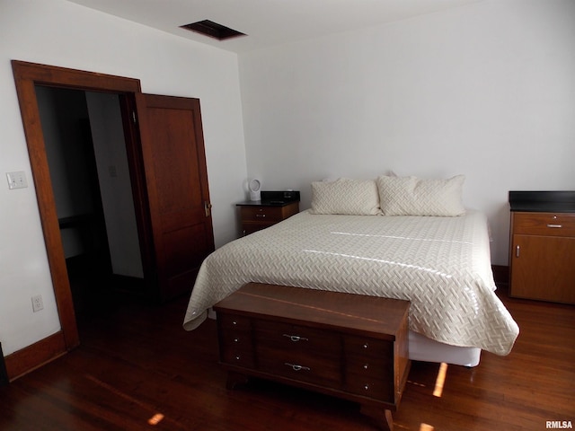 bedroom with dark hardwood / wood-style flooring