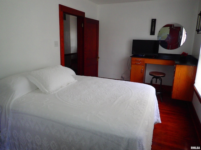 bedroom with dark hardwood / wood-style flooring